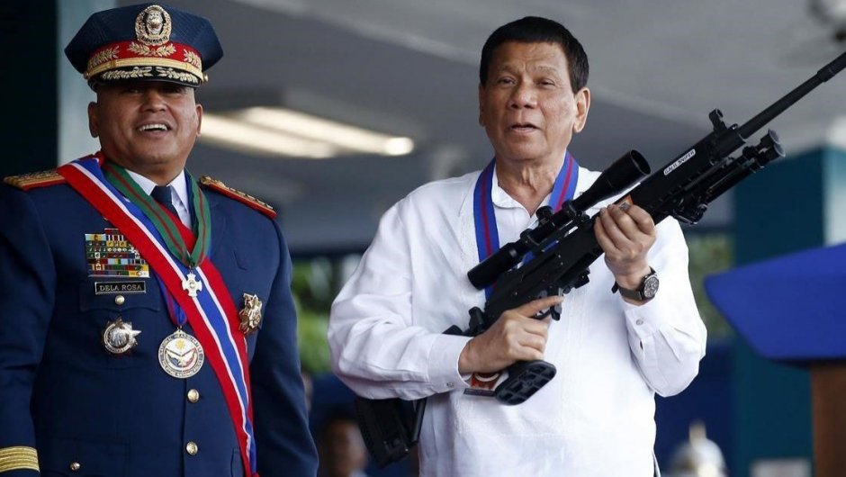 Rodrigo Duterte, sostiene un rifle en una ceremonia de la policía nacional. 